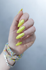Female hand with long nails and neon yellow green manicure