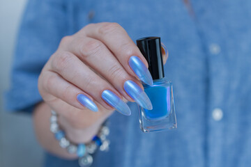 Female hand with long nails and light baby blue manicure