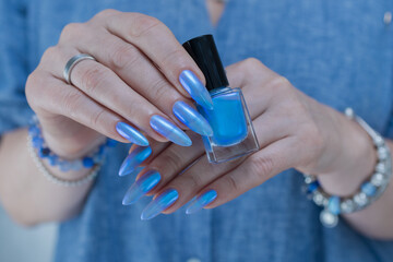 Female hand with long nails and light baby blue manicure