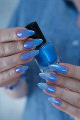 beautiful female hand with long nails, bright blue manicure 