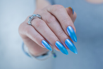 Woman's beautiful hand with long nails and light baby blue manicure	