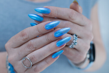 Woman's beautiful hand with long nails and light baby blue manicure	