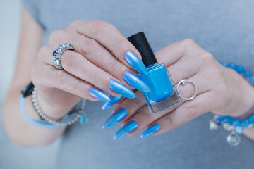 Woman's beautiful hand with long nails and light baby blue manicure	