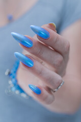 Female hand with long nails and bright light blue manicure	