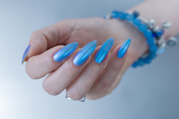 Woman's beautiful hand with long nails and light baby blue manicure	