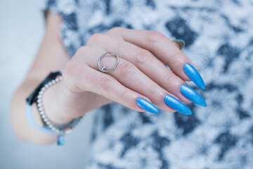 Woman's beautiful hand with long nails and bright blue manicure