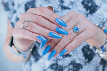 Woman's beautiful hand with long nails and bright blue manicure