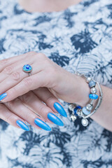 Woman's beautiful hand with long nails and bright blue manicure