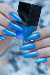 Woman's beautiful hand with long nails and light blue manicure	