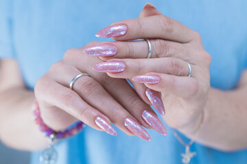 Fototapeta premium Woman's hands with long nails and light pink color nail polish