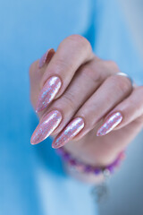 Woman's hands with long nails and light pink color nail polish