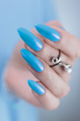 beautiful hand with long nails and light baby blue manicure	