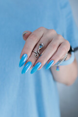 beautiful hand with long nails and light baby blue manicure	