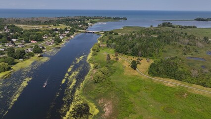 Peaceful river at Braddock Bay, NY at Lake Ontario in summertime with residential neighborhood and boats on water