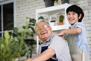 Fototapeta premium A man and a boy are smiling and hugging each other.A boy massages his grandfather's back for comfort.