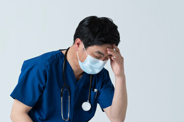 憂鬱な表情の50代医療従事者