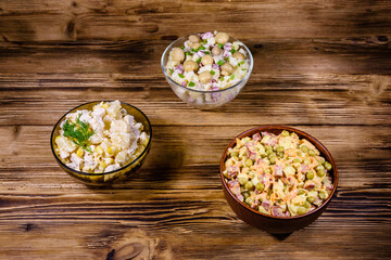 Set of festive mayonnaise salads on wooden table