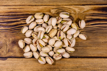 Pile of pistachio nuts on a wooden table