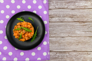 Salmon tartare with arugula on a wooden background. Top view