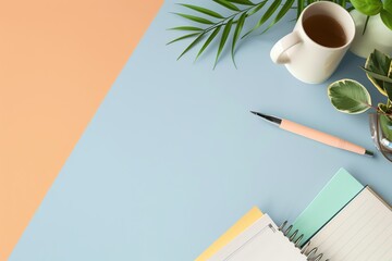 A flat lay of a desk with a cup of tea, a notebook, a pen, and plants on a blue and peach background.