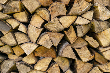 Firewood storage concept. Natural sawn wood stacked in row, texture. Stacks of chopped logs as background. Romantic winter in front of fireplace. Wallpaper.