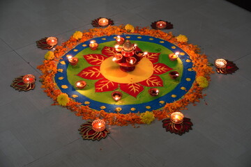 Colorful handmade rangoli design on the occasion of the Indian festival Deepawali with oil lamps lit on colorful rangoli. Hindu traditional. Happy Deepavali. 