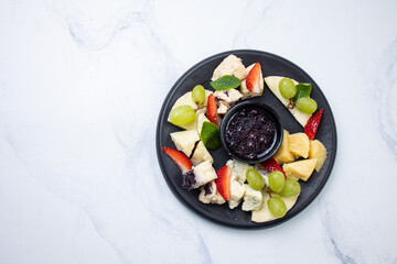 Cheese plate with crackers, nuts and herbs on white background