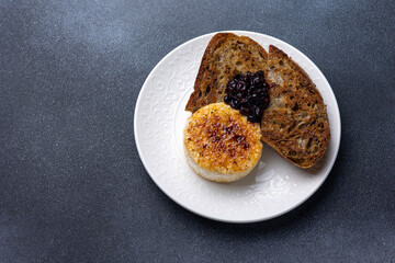 Grilled camembert cheese with black currant jam and toasted bread