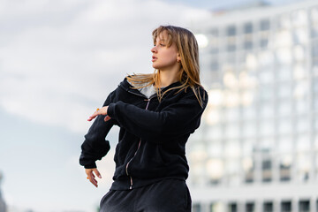 Young Dancer Performing Urban Dance Routine in City Plaza During Late Afternoon