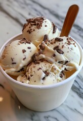 Delicious vanilla ice cream with chocolate shavings, served in a classic white cup.