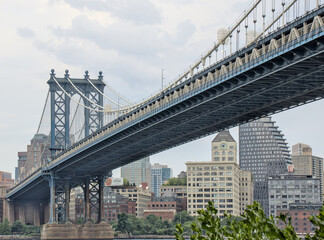manhattan bridge detail (downtown lower east side view looking towards brooklyn with hudson river) famous landmark with tall buildings skyline background famous new york city travel destination nyc