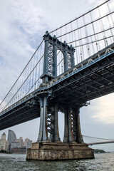 manhattan bridge detail (downtown lower east side view looking towards brooklyn with hudson river) famous landmark with tall buildings skyline background famous new york city travel destination nyc
