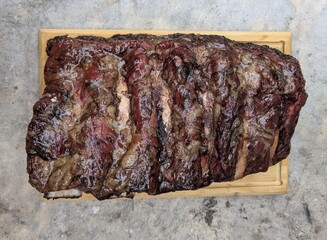 Cooked long ribs in one piece on wooden plate