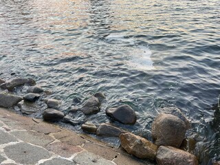 Sea waves hitting the shore with some stones 