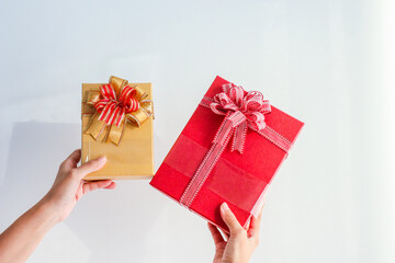 Young woman holding gift box with red satin ribbon bow.