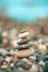 A pyramid of stones on a pebble beach by the sea, the concept of balance, calm, tranquility, relaxation with copy space