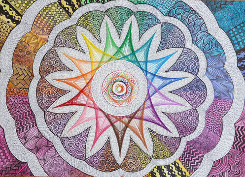 The handmade fusion of string art and doodle art on paper: colourful Solar pattern at centre with thread encircled with floral pattern using doodle patterns with colours