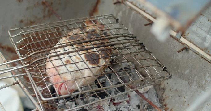 Grilled ruby ​​fish with salt.Grilled ruby ​​fish with salt is a food that Thai people like.Handheld footage.