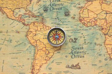 Classic round compass on background of old vintage map