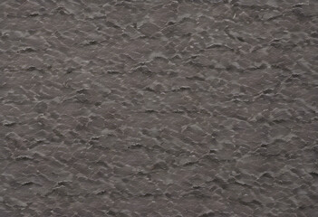 Obraz premium A textured surface with a dark gray color, featuring a rough, uneven pattern that resembles natural stone or concrete.