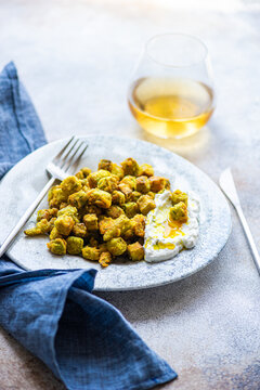 Fried bamia with sour cream sauce, dill, and garlic on plate