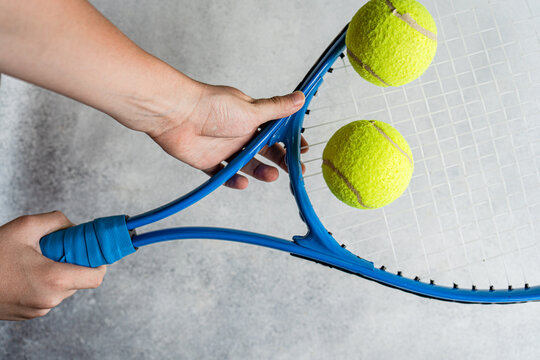 Closeup of a person's hand holding a tennis racket