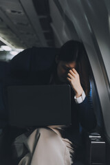 Beautiful Asian businesswoman working with laptop in aeroplane. working, travel, business concept