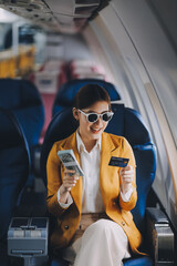 A young Asian woman, seated as an airplane passenger, contemplates dollar bills, reflecting on lucrative opportunities and aspirations towards billionaire status.