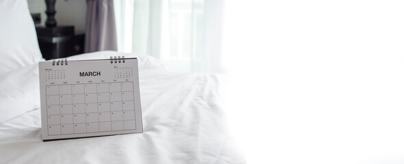 Calendar desk placed on bed. Desktop Calender for Planner to plan agenda, timetable, appointment, organization, management each date, month, and year at home office. Calendar 2024 Concept-banner image