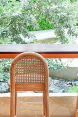 Wicker chair and wooden table in restaurant,Rattan chair in scandinavian interior of living room,Mediterranean minimal wall and green plant exterior architecturer,warm beige tones,copy space.