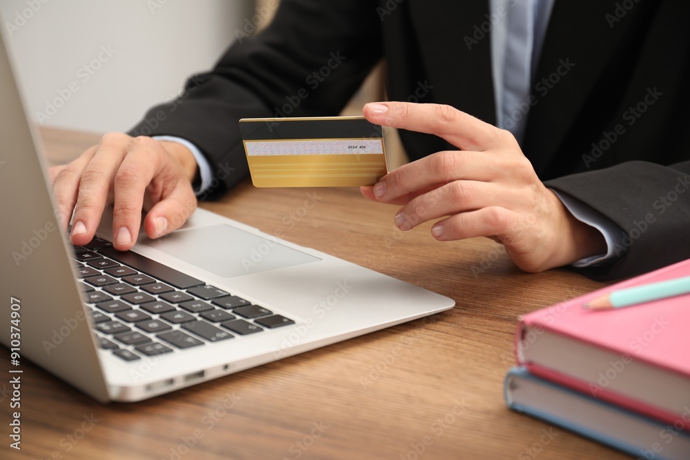 Canvas Prints Man with credit card using laptop at wooden table indoors, closeup