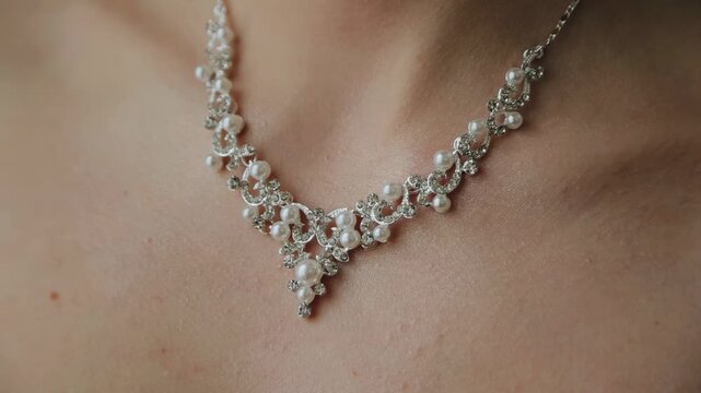 A beautiful necklace is worn around the girl's neck. The camera takes a close-up of the jewel