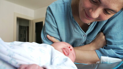 Mother's tender moment with her newborn baby, cuddling infant in loving caring manner, child's...