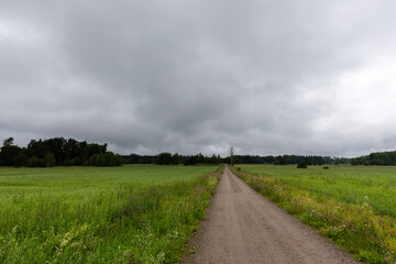 Long straight dirt road stretching into the distance in the countryside of Sweden, Europe